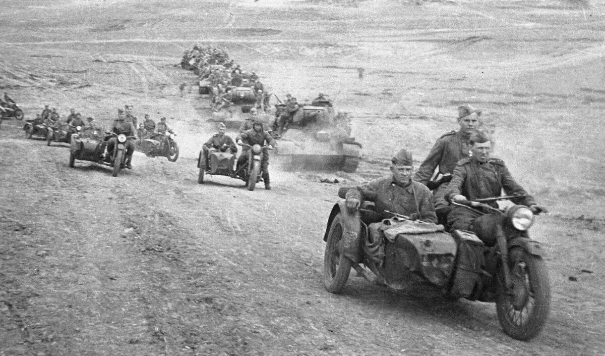 Взвод советских мотоциклистов на мотоциклах М-72 и советские танки Т-34-85 с десантом одного из механизированных корпусов идут в бой за станцию Раздельная в Одесской области
