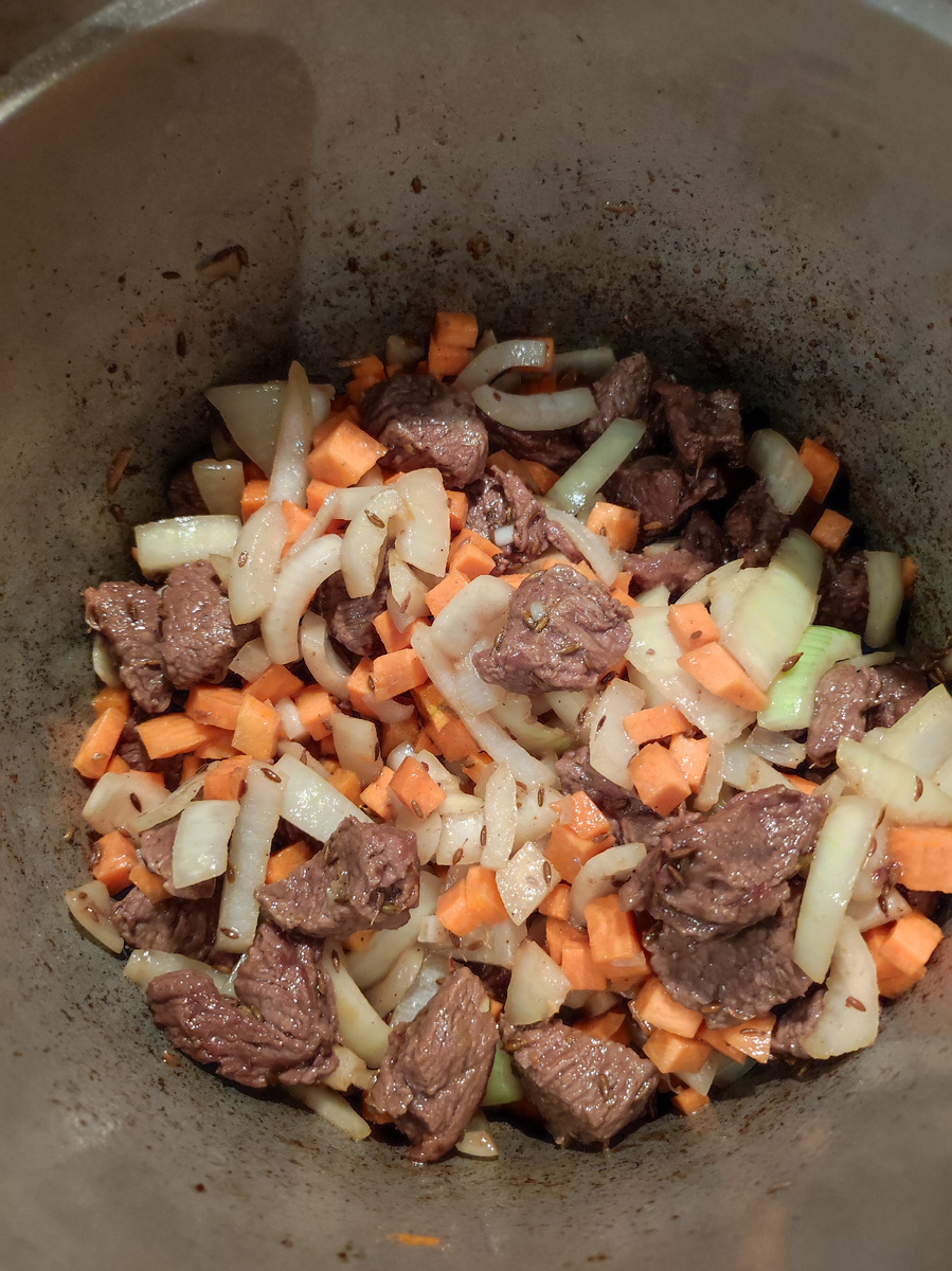 Добавляем нарезанную любым способом морковь, зиру, барбарис и черный перец и обжариваем 2 минуты,