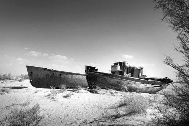 Суда стоят в песке берега Аральского моря