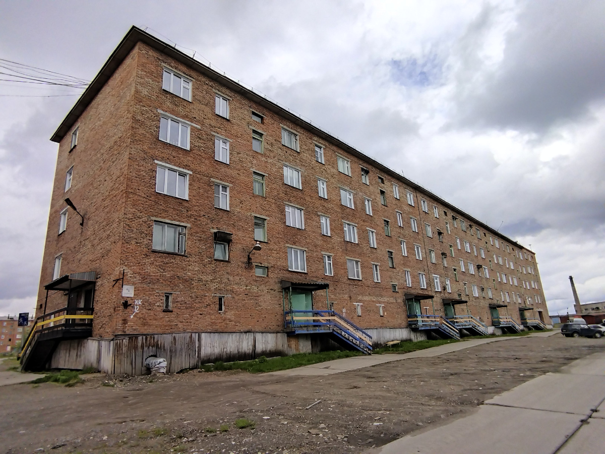 Типичная пятиэтажка в Игарке. Сваи закрыты досками.