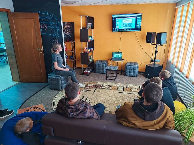 Подростки смотрят на экран телеконференции