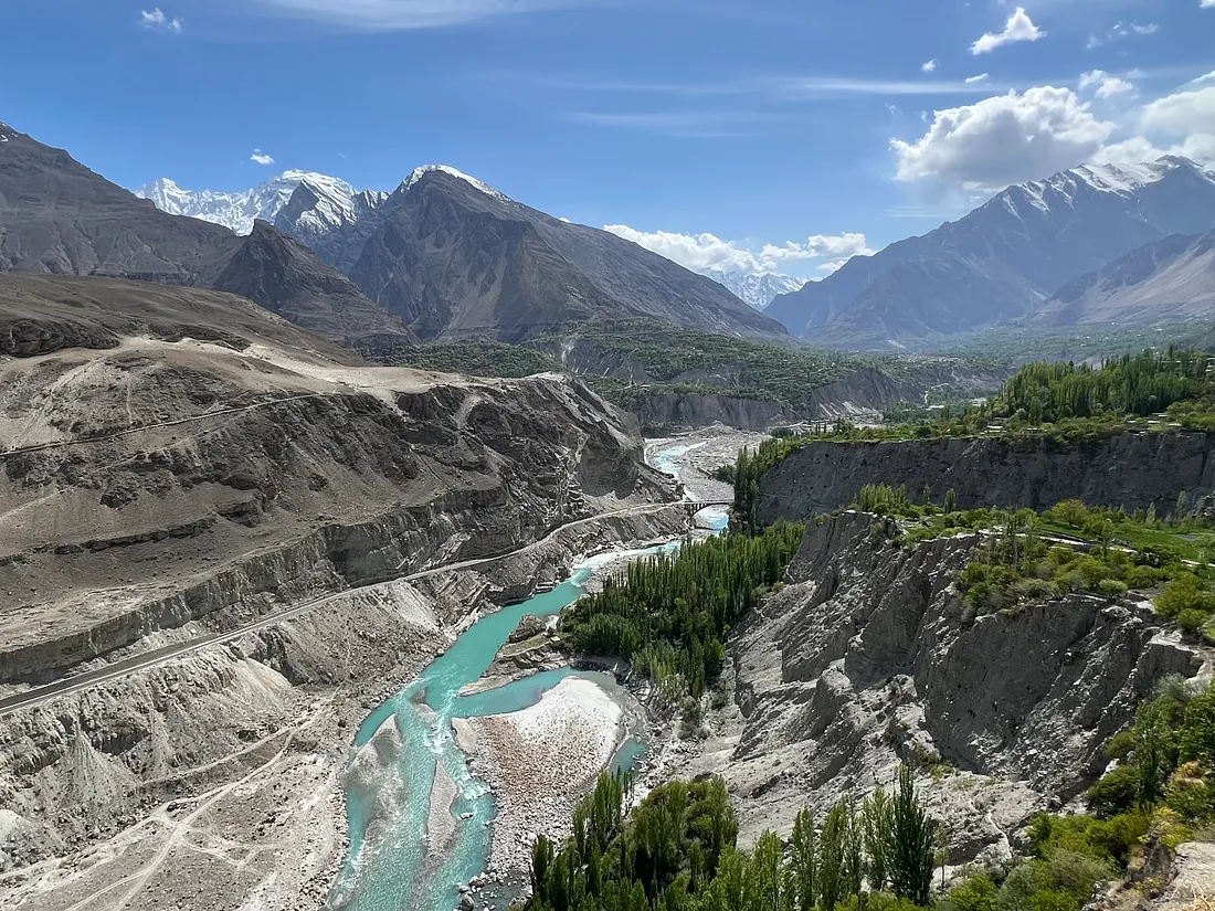 Долина с бирюзовой рекой, лесом на правом берегу и горами вдали