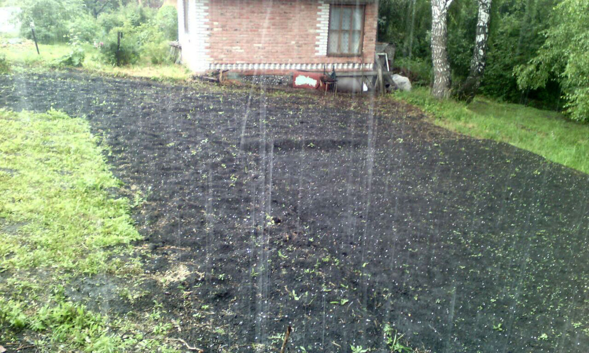 Дождь с градом загнали в домик, не дают террасировать склон. На заднем плане соседский дом, построенный одной стеной на нашем участке. Пришлось потратить время и нервы для уточнения границ.