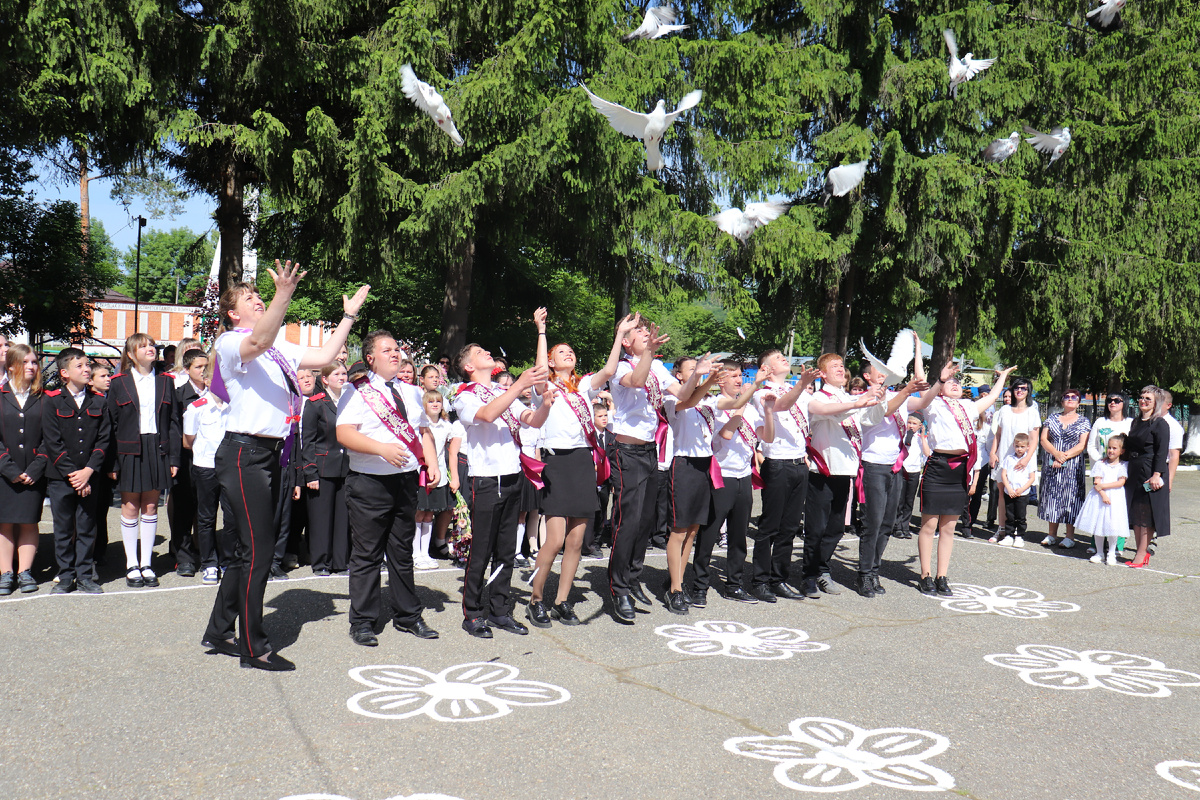 Девятиклассники с классным руководителем Светланой Снегирёвой выпускают в небо голубей.