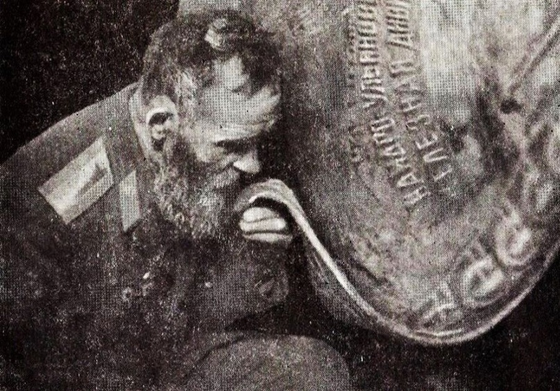 Дмитрий Тяпин у спасённого им знамени. Источник изображения: https://rodina-history.ru/2024/03/25/angel-hranitel-zheleznoj-divizii-kak-kolhoznik-dmitrij-tiapin-spas-ee-znamia.html