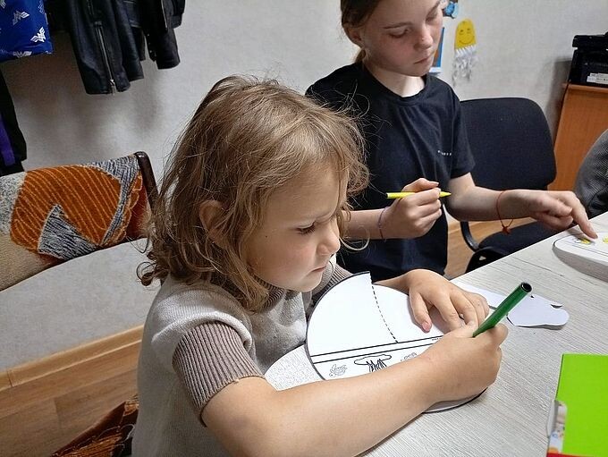 Девочка рисует карандашом на бумаге