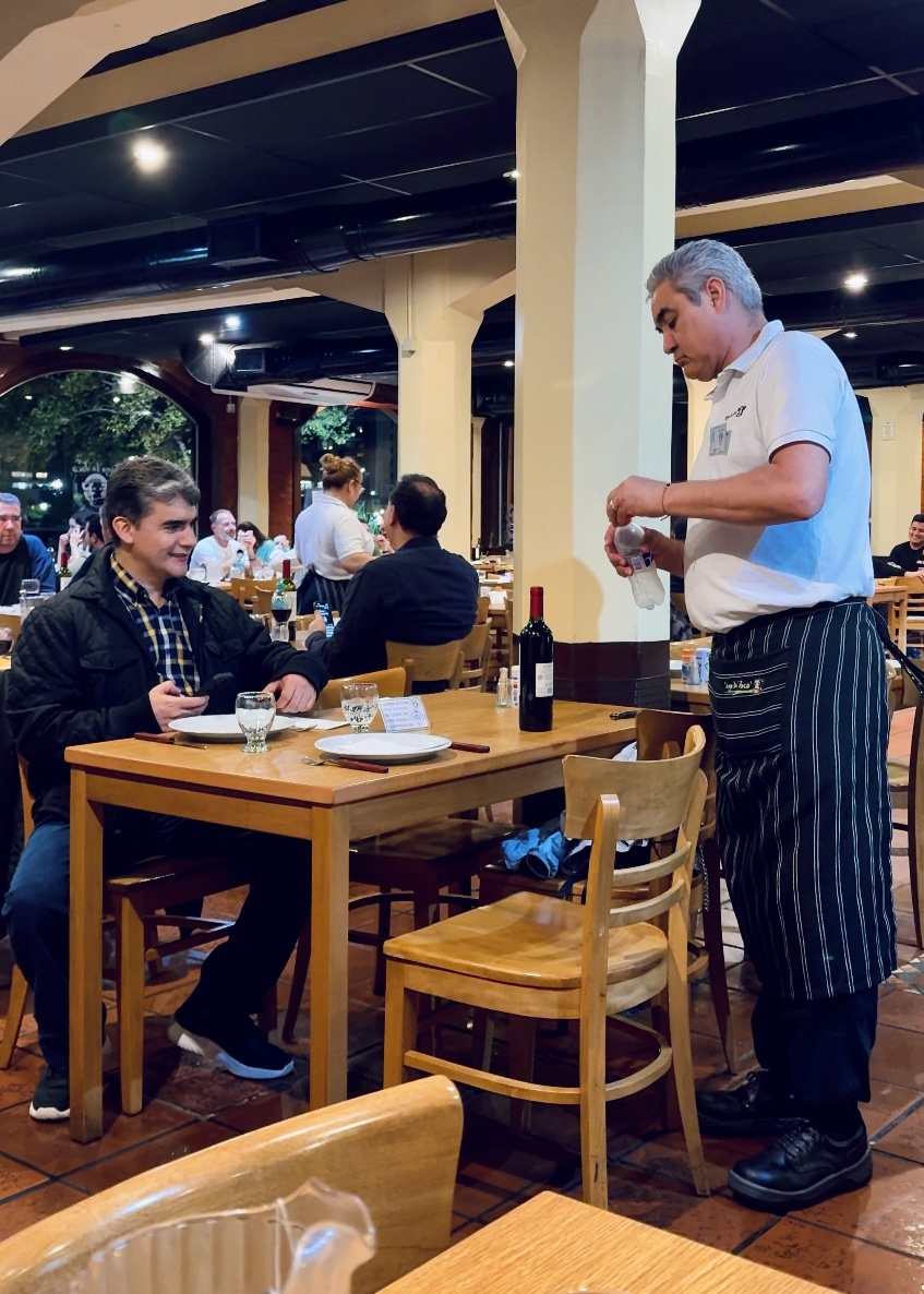 Если приглядеться, то можно увидеть, хомут (на стуле рядом с официантом), которым прикреплена сумка 