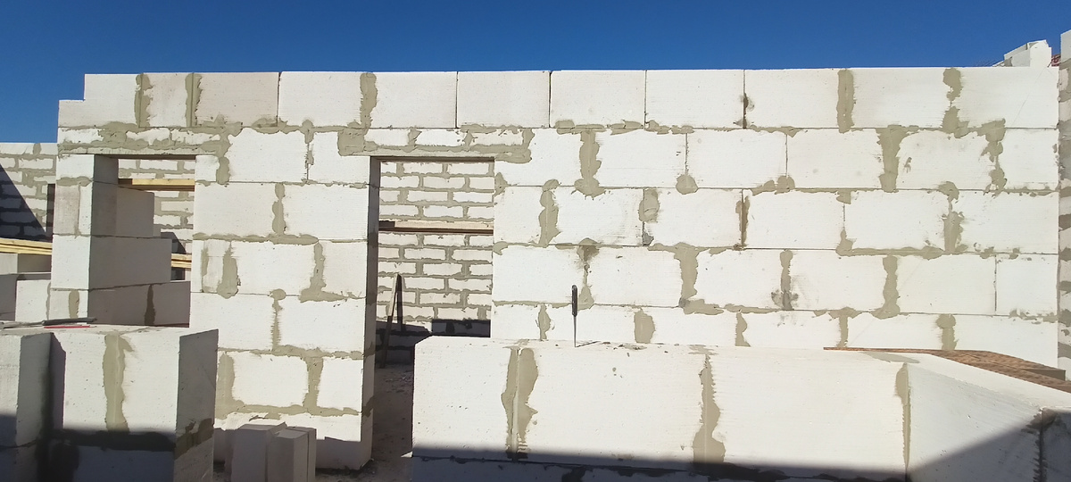 Бытование стен газоблоком начинаем с того, что первый ряд всегда ложим на раствор, так как этот ряд выравнивающий. Далее замешиваем клей специальный для ячеистых блоков, консистенция должна быть такой, чтобы клей не растекался сильно, как густая сметана. Далее накладываем кельмой на газоблок клей , размазываем по поверхности, проводим гребенкой, зубья 5 мм и садим блок по уровню и т. д. 