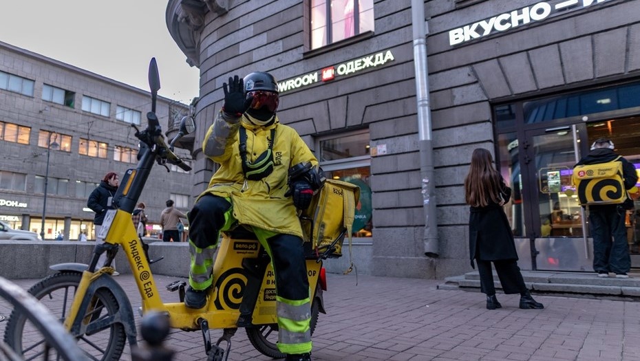    Курьеры доставки на электробайке у ресторана быстрого питания и магазина одежды в Петербурге. Автор фото: Михаил Тихонов / "Деловой Петербург"