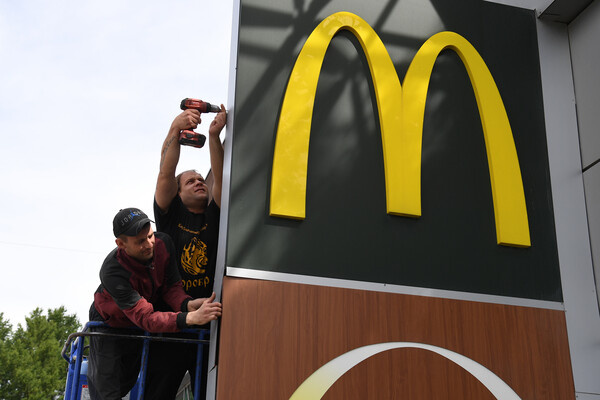 Демонтаж вывески ресторана быстрого питания McDonald's с фасада здания торгового центра, 2022 год / Александр Кряжев/РИА Новости 