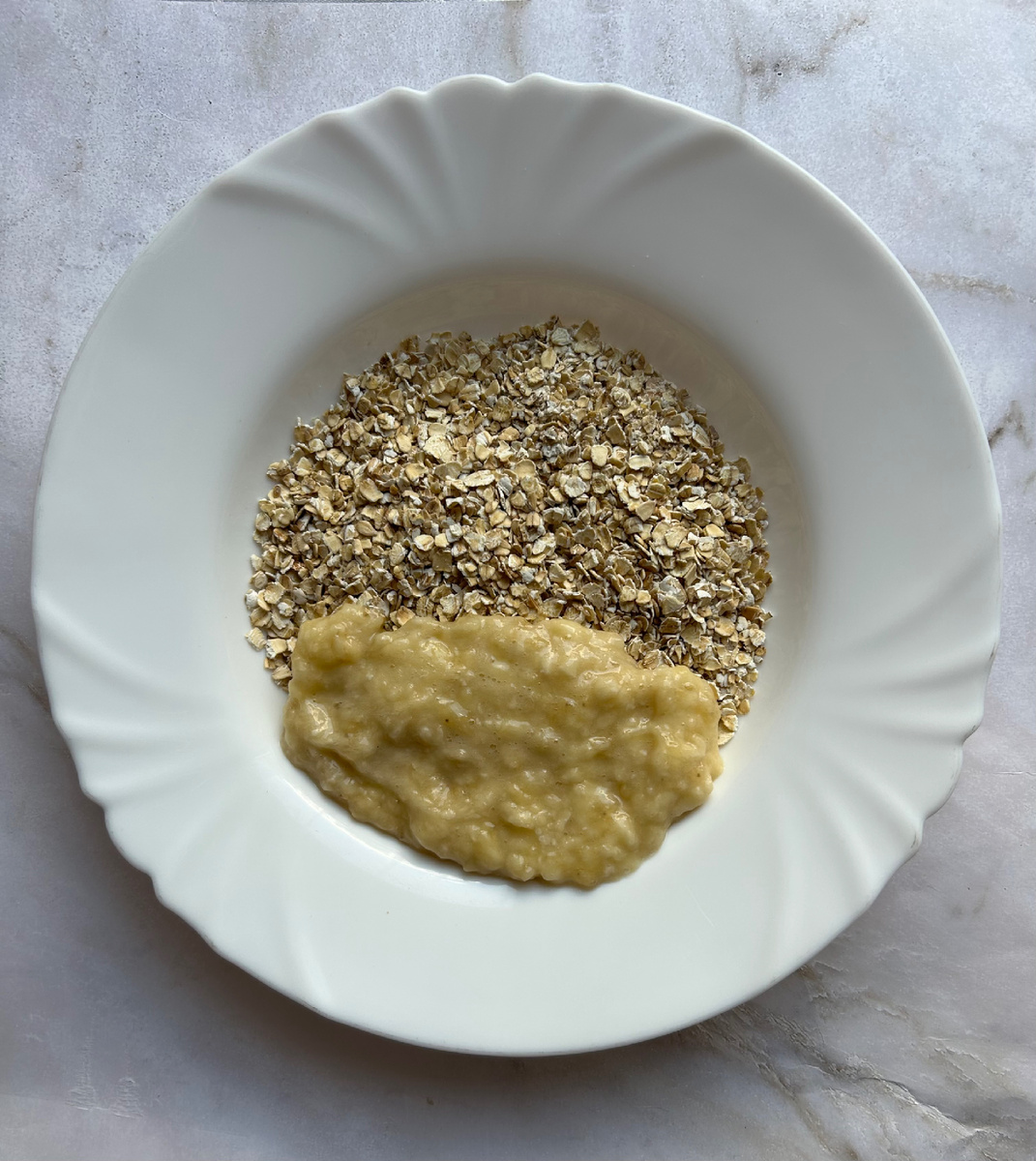 Вилкой разминаем банан до кашицеобразного состояния и добавляем к хлопьям.