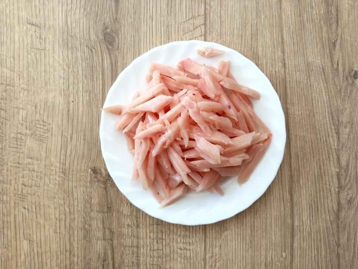 Куриную грудку порежьте соломкой как можно мельче. Если используется другое мясо, с ним нужно поступить точно так же.