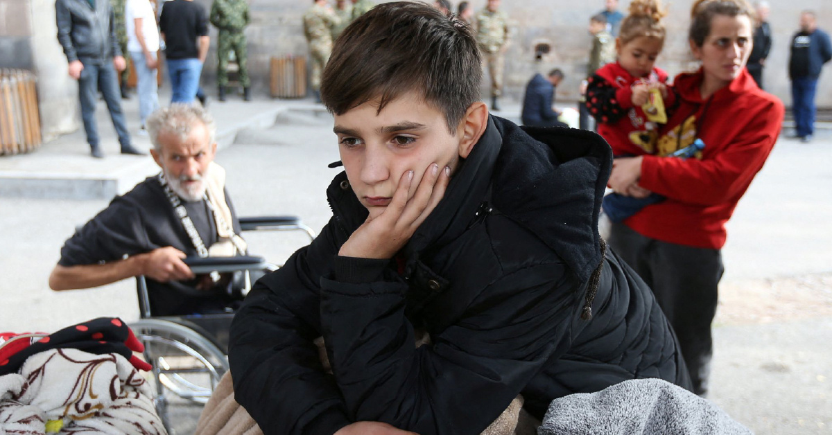 Арцахский беженец-мальчик в Горисе ждет заселения во временное пристанище, 25 сентября 2023 года, автор – Ираклий Генденидзе (Reuters)