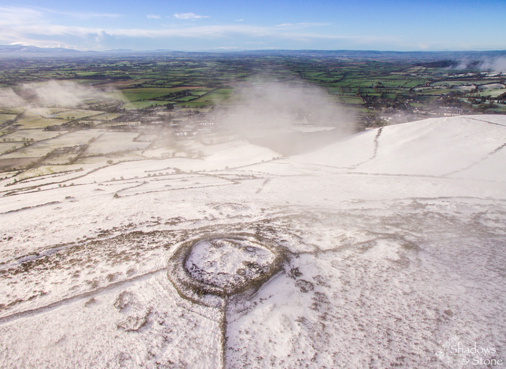 На холме зима, а на равнине трава зеленеет. Каменная стенка вокруг гробниц Балтингласс - новодел, как и каменные изгороди. Хорошо видны наружное кольце бордюрных камней, внутреннее, гробница номер один.