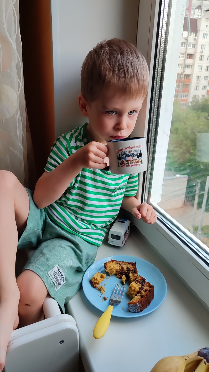 Совершенно довольный жизнью ребёнок пьëт чай с нежнейшим кексом ручной работы. 