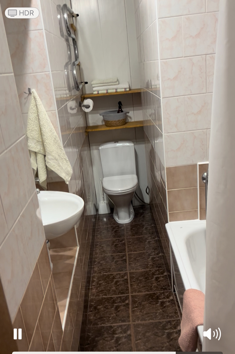 узкое помещение со встроенной нишей для раковины и небольшой сидячей ванны