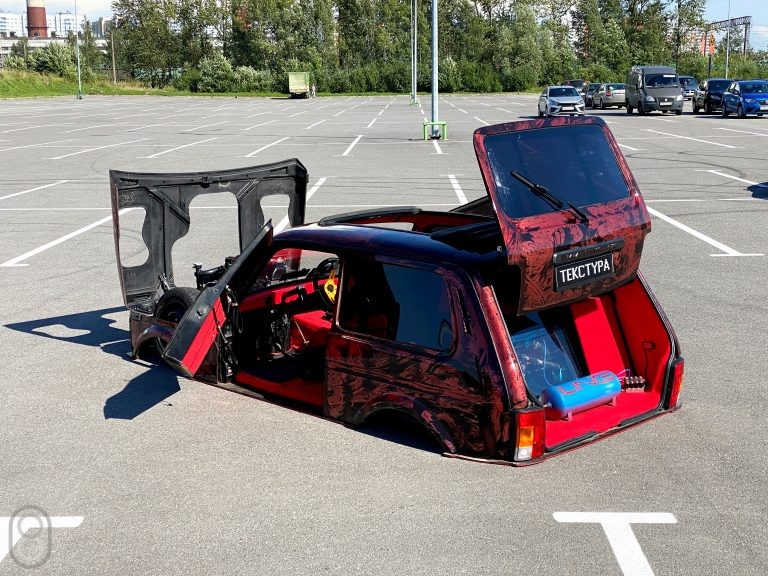 Самая низкая ниваВ нашей стране полно умельцев, реализующих классные автомобильные проекты. Не так давно мы смотрели «Волги»-лоурайдеры, которые умеют прыгать, реплику Lamborghini Gallardo, собранную из разбитой Mitsubishi и даже копию Tesla Cybertruck на базе УАЗа.Парни с YouTube-канала iling show пошли еще дальше и сделали что-то совершенно безумное — самую низкую «Ниву», которая буквально лежит на земле. Проект стартовал в июле 2019 года и за это время в конструкцию машину были внесены колоссальные изменения.Практически все элементы полностью переделаны: автомобиль усилили по контуру, сделали кастомное рулевое управление, кардан и петли багажника. Чтобы колеса зашли внутрь кузова, мост и подрамник поставили от «Жигулей». В процессе сборки ребятам вообще приходилось много импровизировать, а что-то и вовсе приваривать почти наугад.Самая низкая ниваТак, выхлоп выведен напрямую из капота, а пятилитровый бак разместили в довольно неожиданном месте — в ногах пассажира. Его можно попросту вытащить и никто не сможет угнать машину. Чтобы на этой «Ниве» хоть как-то ездить, спереди и сзади установили пневмоподвеску, приподнимающую кузов над землей при необходимости — она преодолеет даже лежачего полицейского.Самая низкая ниваКрышу пришлось резать и делать ее сдвижной, иначе в салон не поместиться. Да, голова водителя и пассажира немного торчит во время движения, зато внешний вид авто привлекает внимание каждого прохожего.Как и всегда, Ким не упустил возможности прокатиться на такой необычной тачке, а заодно пообщался с владельцем: