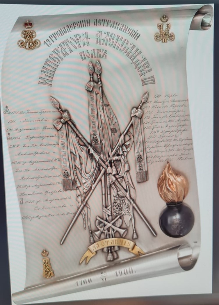 Памятная пластина. Мастерская К.И. Бока. Санкт-Петербург. 1900 г. На пластине в форме свитка изображены знамена и вензеля императоров Петра I, Александра III и Николая II под императорскими коронами, граната с пламенем и вензелем Петра I. Надпись: "12 гренадерский Астраханский Императора Александра III полк". По обеим сторонам знамен — наименования полка и названия битв, в которых он участвовал. "1700. Пех. Романа Брюса полк 1708. [Пех.] Вологодский [полк] 1790. Астраханский гренад[ерский] [полк] 1845. Карабинерный Е.И.В. Вел. Кн. Александра Александровича п[олк] 1864. 12-ой гр. Астраханский Е.И.В. Вел. Кн. Александра Александровича полк 1865. 12 гр. Астраханский Е.И.В. Наследника Цесаревича п[олк] 1881. 12 гр. Астраханский Его Величества п[олк] 1894. 12 гр. Астрах. Имп. Алекс. III полк"; "1700. Нарва 1702. Нотебург, Ниеншанц 1709. Полтава, Пернов 1713. Гельсингфорс 1714. Гангеуд, Стокголм 1720. Гренгам 1736. Азов 1757. Гросс-Эгерсдорф 1759. Кунерсдорф 1760. Берлин 1770—1771. Азов 1812. Шевардино, Бородино, Малоярославец 1813. Лейпциг 1814. Ла-Ротьер 1831. Остроленка, Воля, Варшава 1877. Плевна". Внизу свитка: "25/VI 1700 — 25/VI 1900". https://rm.shm.ru/core/item/393