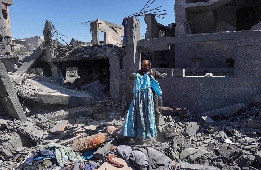 Палестинец под обломками взорванного израилем дома в лагере Нусейрат / Gettyimages.ru