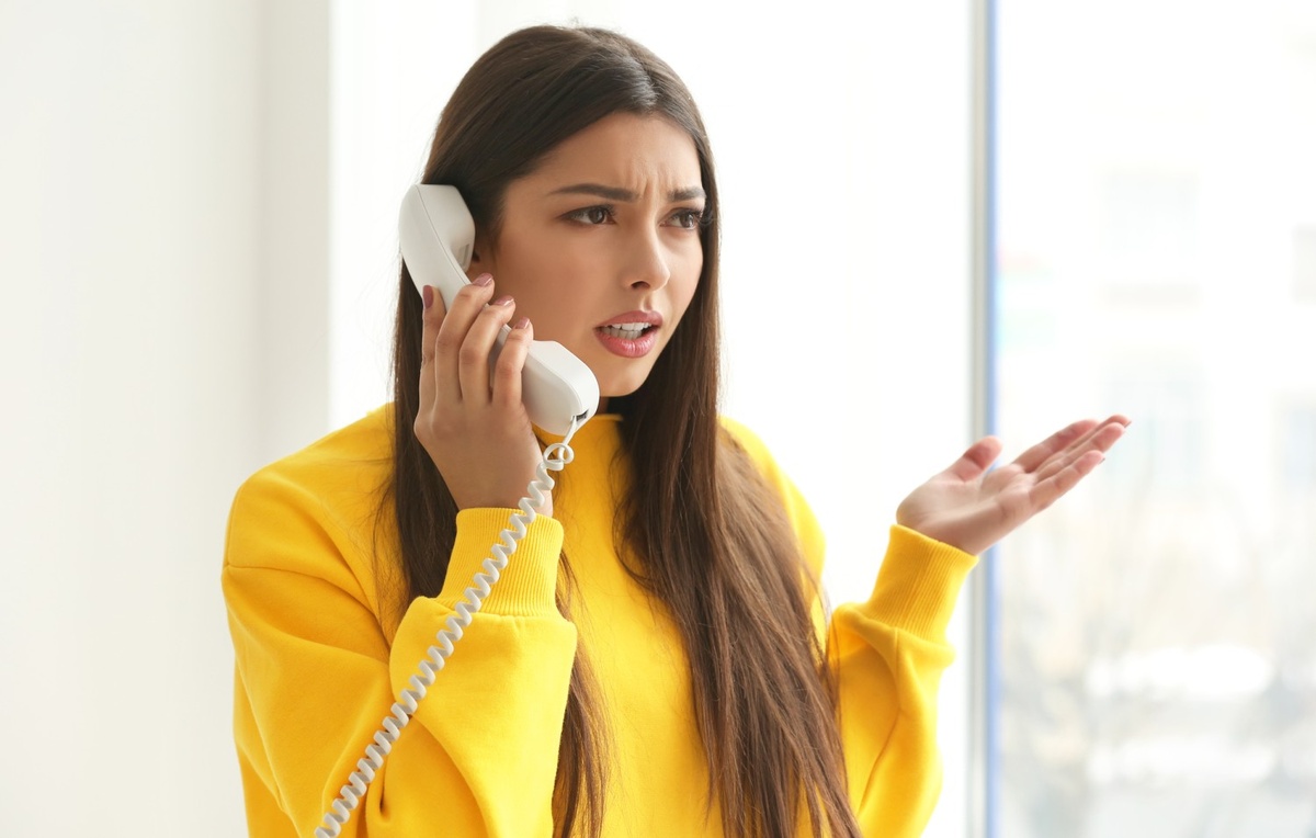 встревоженная девушка говорит по телефону