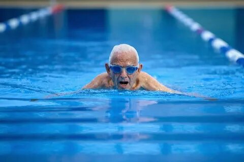  Пожилой мужчина плавает в бассейне