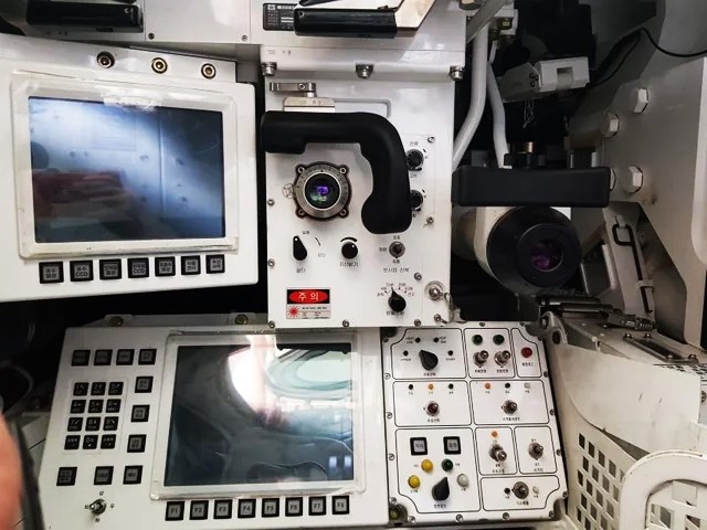 Рабочее место наводчика. Слева- видеомонитор тепловизионного канала, внизу- многофункциональный дисплей системы C4L. Справа-окуляр вспомогательного телескопического прицела.