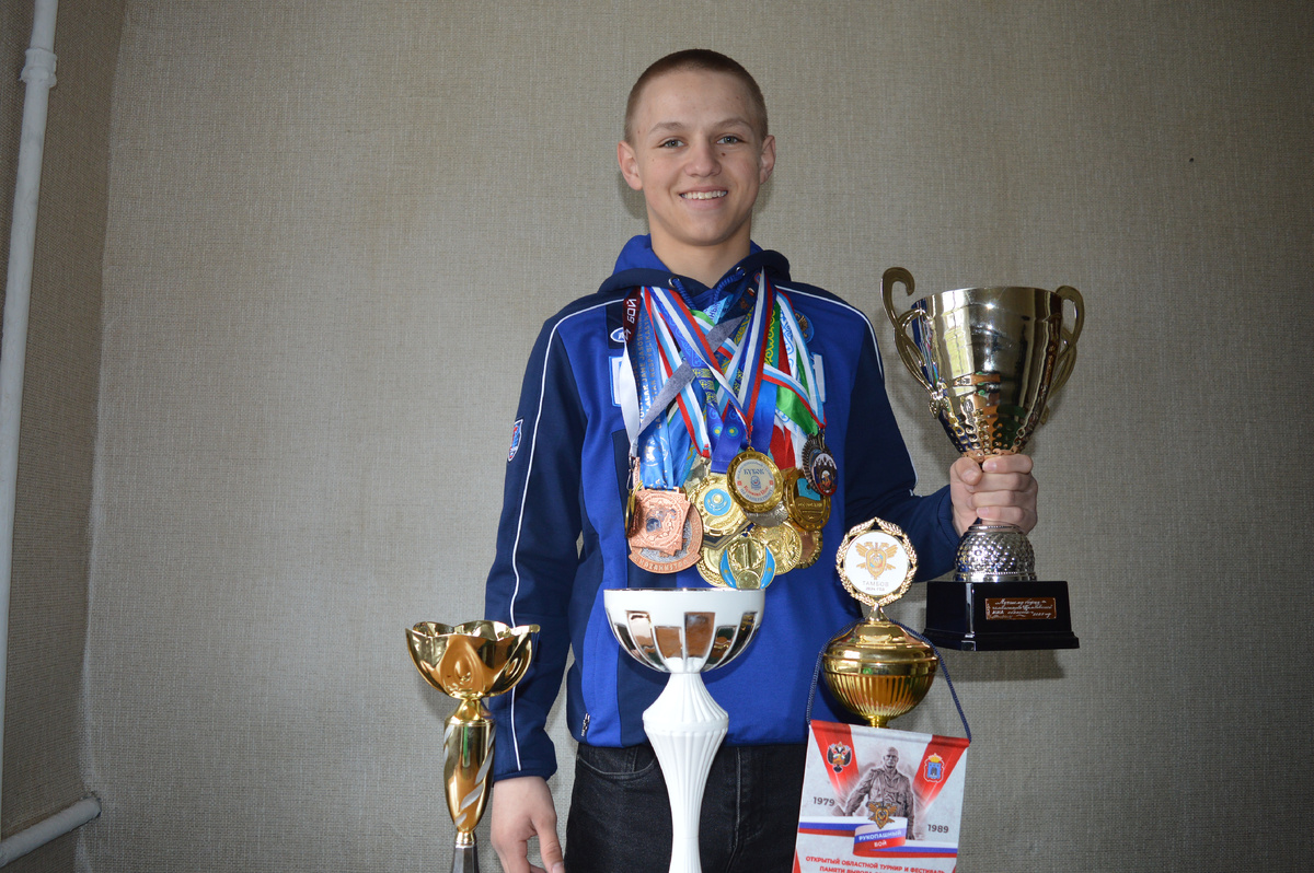 
Кирилл Дьяченко со своими наградами по смешанным боевым искусствам и рукопашному бою. В руке  — кубок победителя чемпионата Тамбовской области по СБЕ ММА.