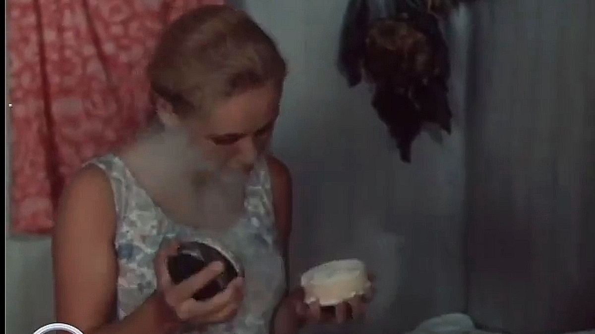 Кадр из фильма. На стене висит на вешалке парадное платье, а Варька неумело открыла пудру и теперь вся в облаке