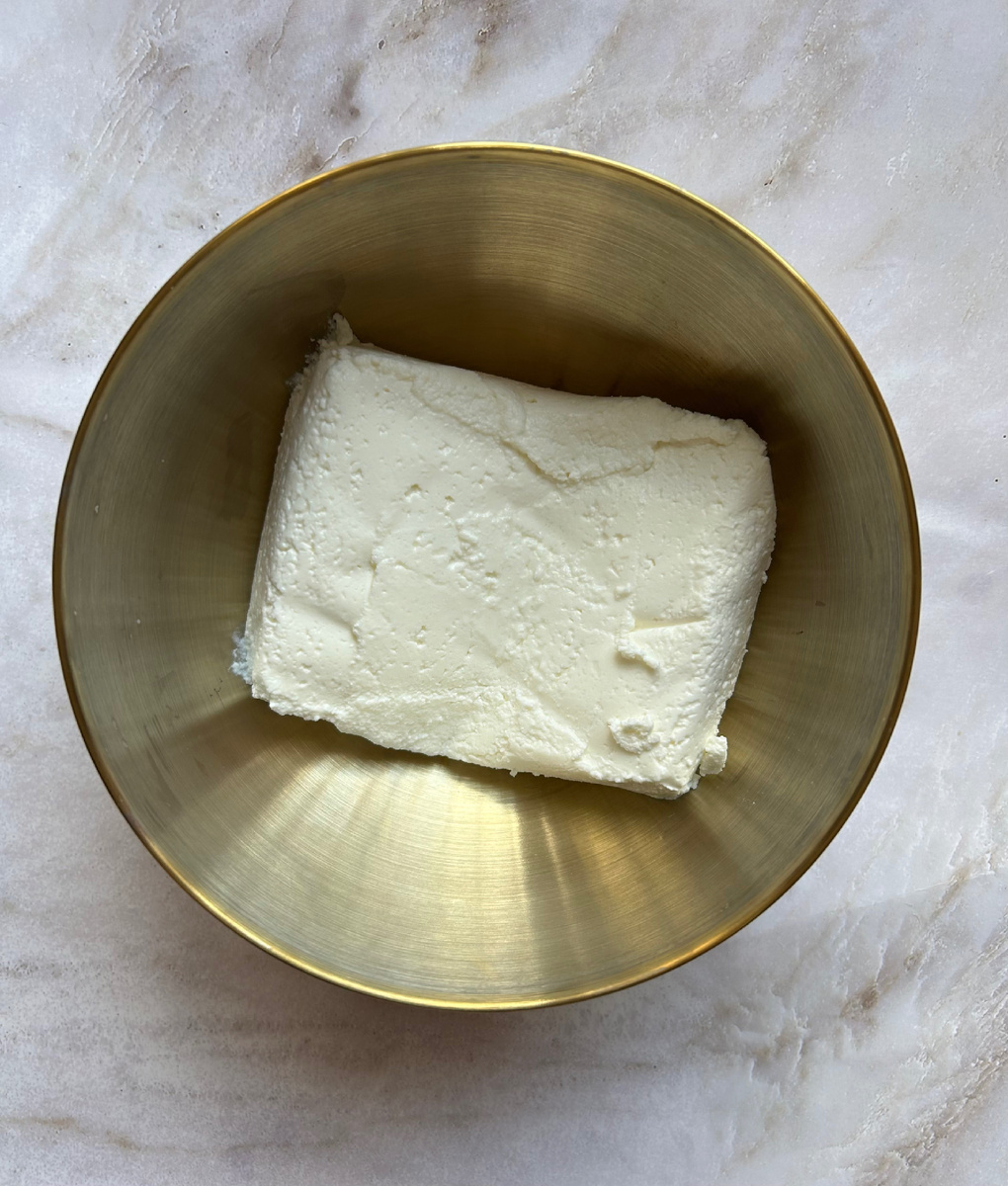 В глубокую ёмкость выложить творог.