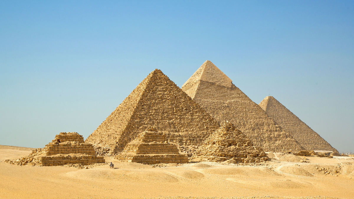 Вид на пирамиды в Гизе. Слева направо: пирамиды Микерина, Хефрена и Хеопса. Три небольшие пирамиды на переднем плане — это пирамиды-спутницы пирамиды Микерина.