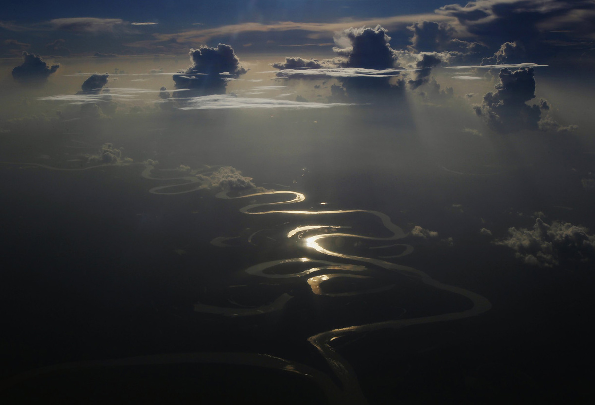 Река Амазонка на рассвете: отражение солнечного света на воде 