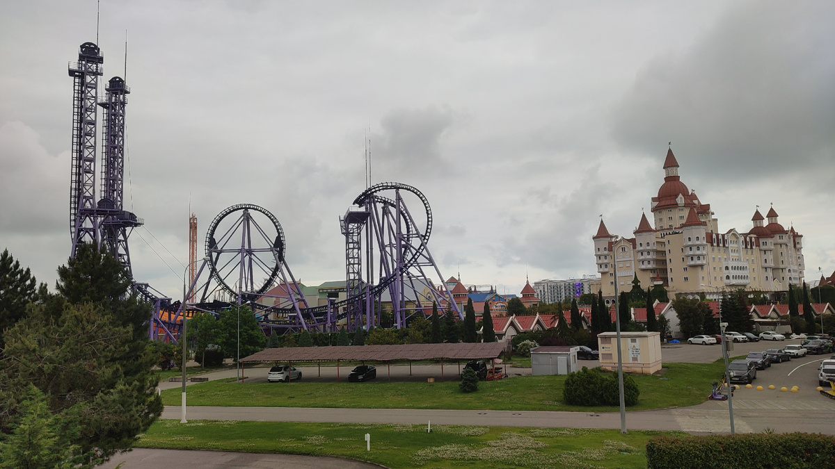 Общий вид на Сочи Парк: парк развлечений - американские горки, отель-замок "Богатырь", справа часть парковки. Справа возле отеля - едва заметная надпись "Сириус" 😊