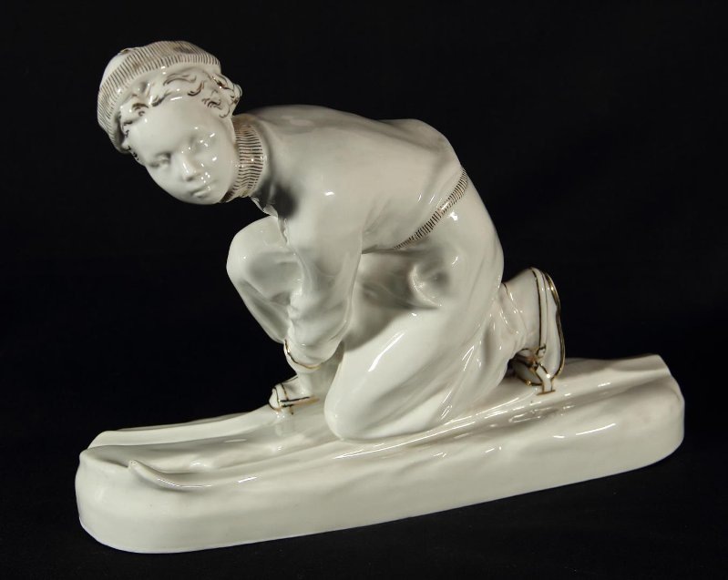 "Лыжница". Скульптура в "стандартной росписи золотом 1958-го года. Модель 1955-го года. Автор модели Павловская Н.А. Размеры: 19,3*24,8*7,5 см. Государственное автономное учреждение культуры Ярославской области "Рыбинский государственный историко-архитектурный и художественный музей-заповедник". Листайте галерею вправо.