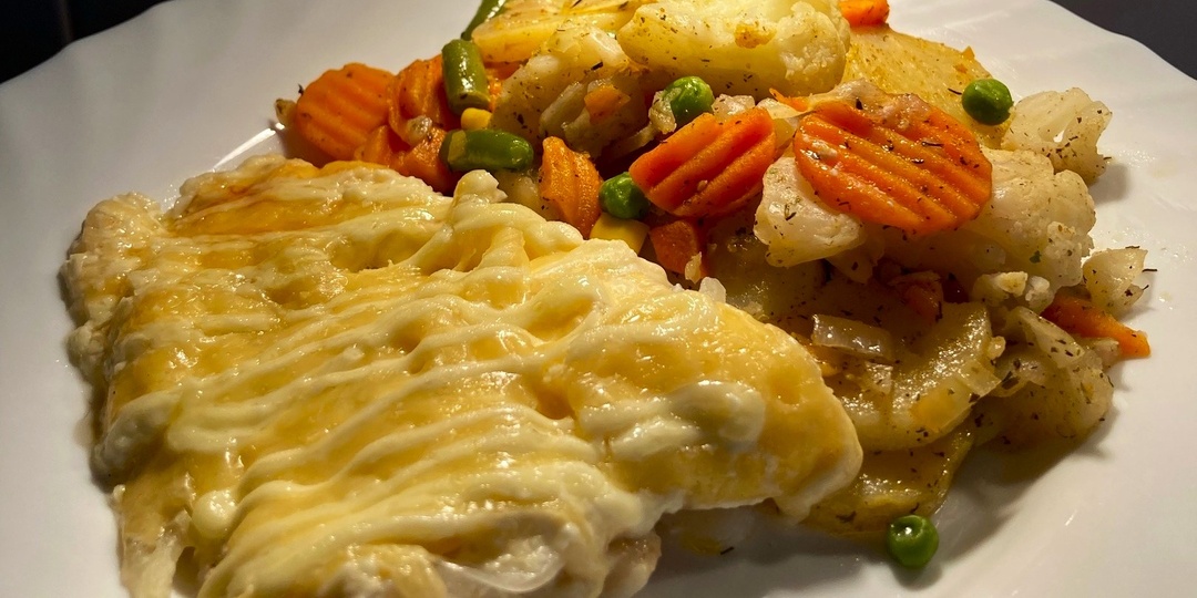 Треска под сырной шубкой с запеченными овощами: простой и вкусный ужин.