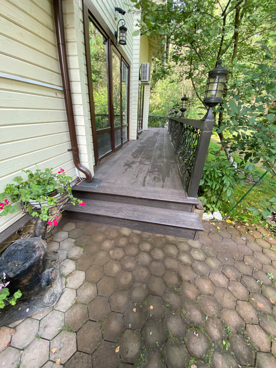 Площадка побольше, с двух сторон дома и вход на террасу.