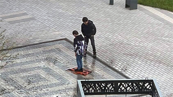    "Мы просто играли с цветной тряпочкой" - дети мигрантов наивно объяснили, зачем осквернили символ воинской славы России // Скриншот: видео с камеры наблюдения