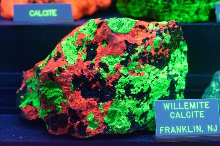 Виллемит (зел.) с кальцитом (красн.) под ультрафиолетом. Месторождение Франклин, штат Нью-Джерси, США. Автор: Jud McCranie. Источник: https://commons.m.wikimedia.org/wiki/File:Willemite_calcite_...