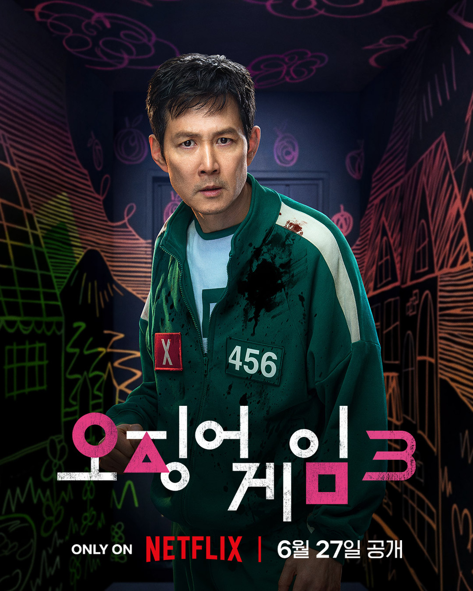 Здесь изображён ги Хун (игрок 456) в комнате с разными рисунками. Либо это локация с игры ножики ключики. Либо с последней игры. И на его одежде видна кровь. Значит он убил человека в игре с ножиками и ключиками 