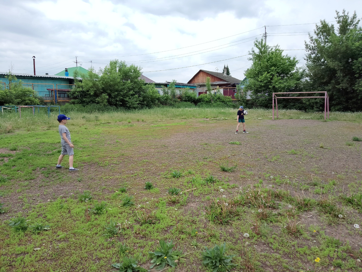 Вадим и Паша в футбол играют на поле в частном секторе