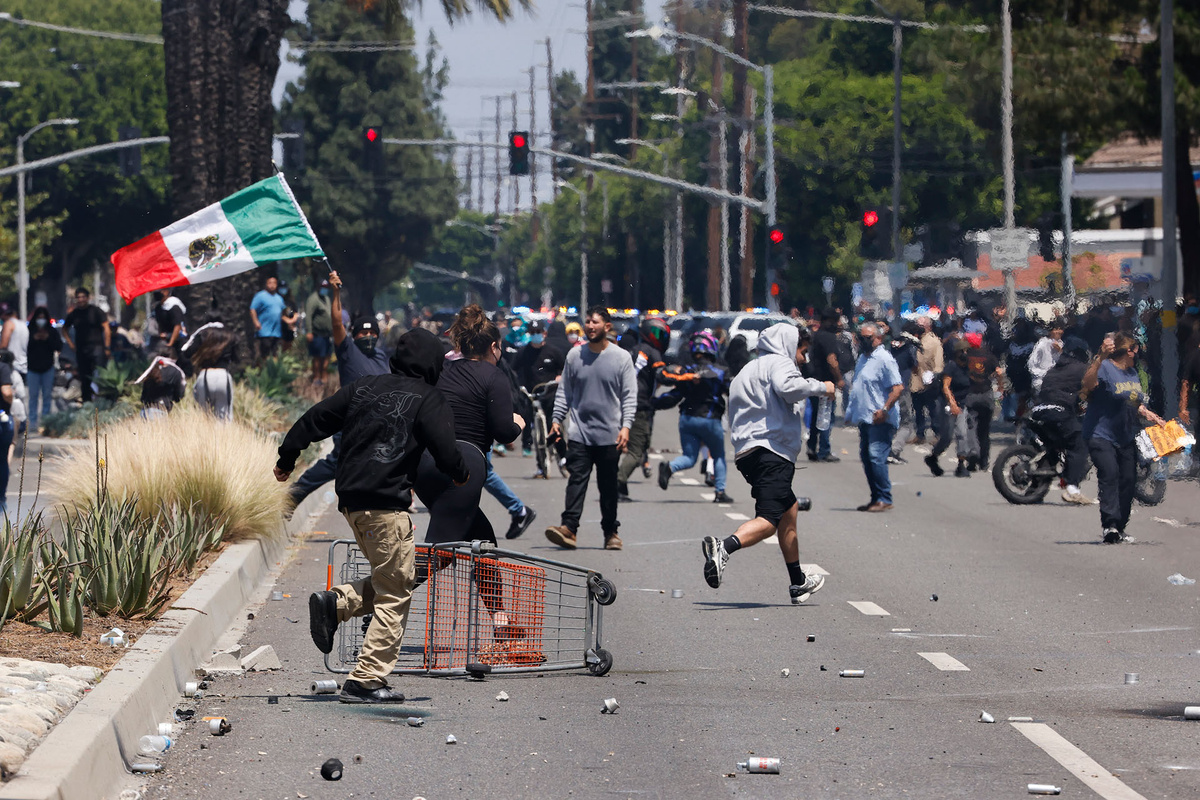    Протестующие убегают от слезоточивого газа и светошумовых гранат, выпущенных сотрудниками полиции, 7 июня 2025 года