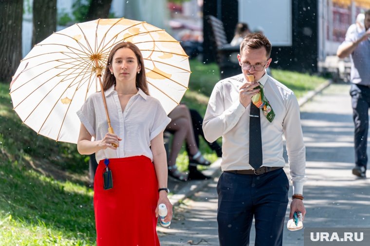 Офисных работников во время перерыва спасает зонт и мороженое. Фото: Руслан Яроцкий © URA.RU