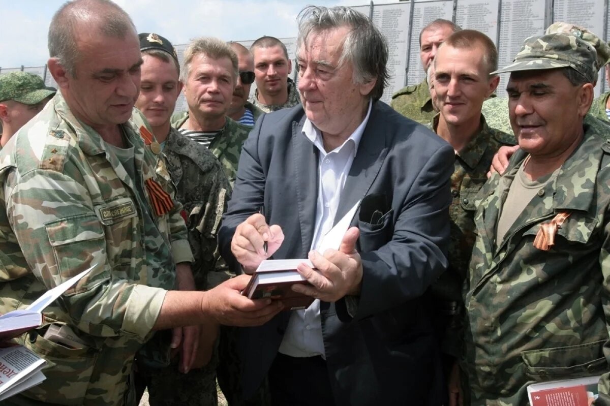    К горячим точкам писателю не привыкать. Александр Проханов раздаёт автографы бойцам у мемориала Саур-Могила в Донецке.
