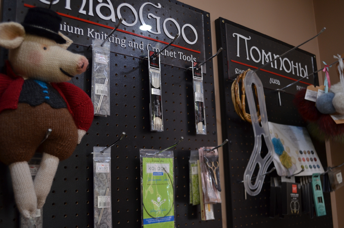 Инструменты для вязания и вязальные аксессуары: спицы, крючки, счетчики и помпоны — всё под рукой для комфортной и творческой работы мастера.