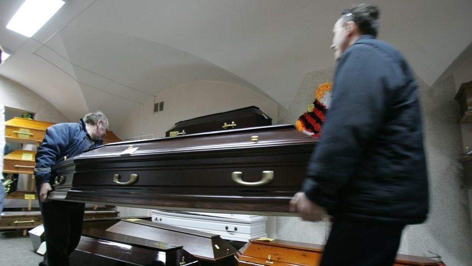    Грузчики Городского ритуальных бюро услуг в Петербурге переносят гроб. Автор фото: Андрей Кульгун / "Деловой Петербург"