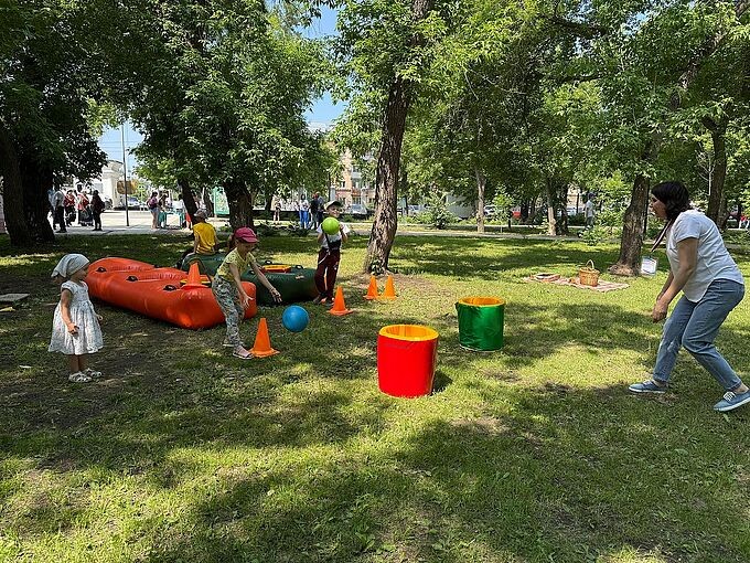 Заречнева Лариса Павловна организует игру детей на поляне парка