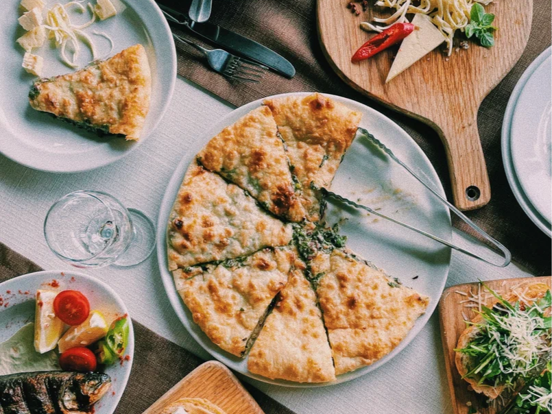 Когда на стол подают три осетинских пирога, старейшина обязательно произносит молитву в порядке очерёдности. Их режут сразу стопкой и только по диагонали. Иногда к трём пирогам добавляют три ребра жертвенного животного, например барашка. Фото: Татьяна Шутько / Яндекс Карты
