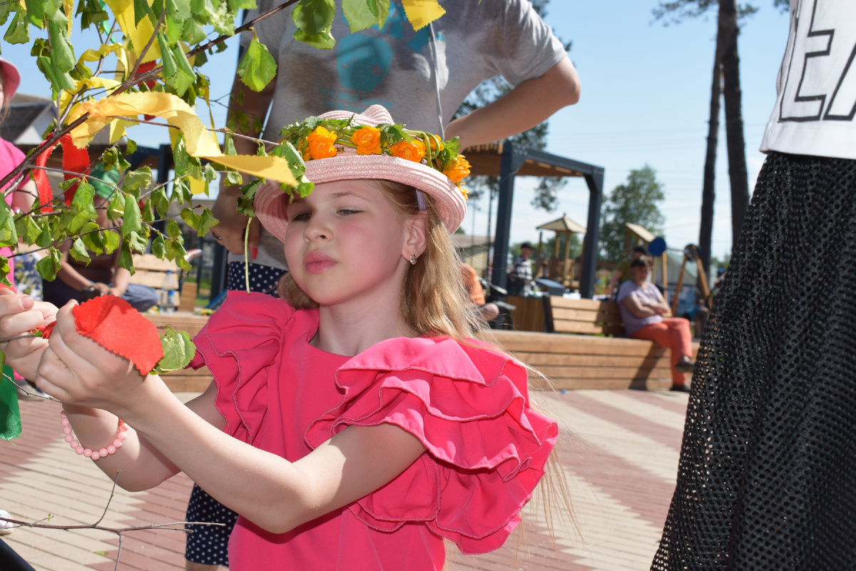На фото: Ленточку на березу повязывает Ульяна Тихонова. 