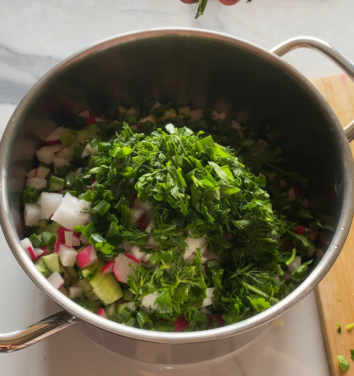 Нарезать все овощи, колбасу мелким кубиком. Зелень мелко порезать.