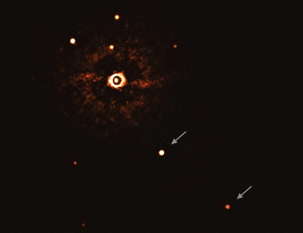 На этом снимке, полученном с помощью инструмента SPHERE на Очень Большом Телескопе ESO, изображена звезда TYC 8998-760-1 в окружении двух гигантских экзопланет.
