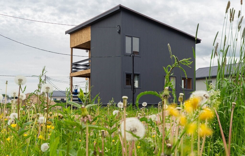 Дом с односкатной крышей, отделка имитация бруса, разного окраса.